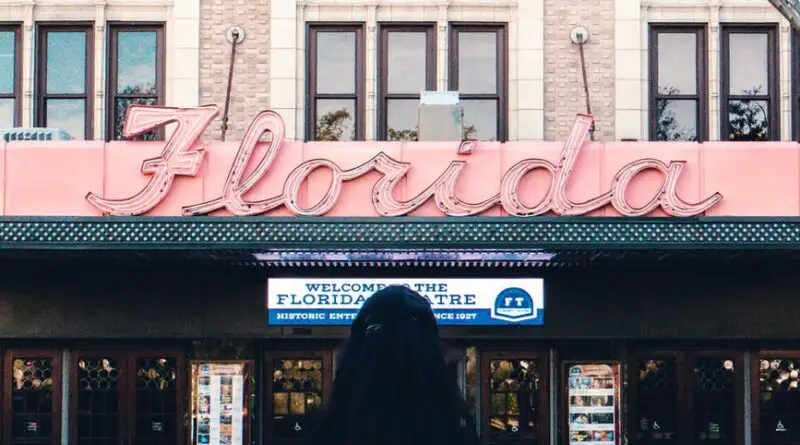 woman in black shirt standing in front of brown and white building