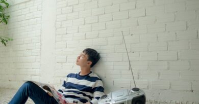 photo of man sitting near radio