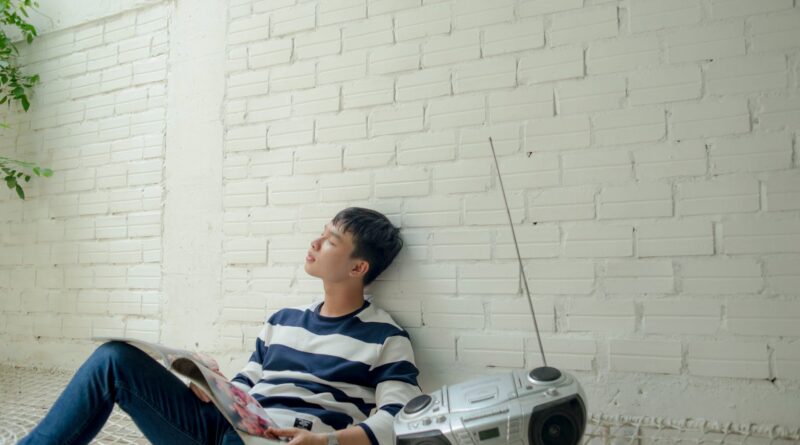 photo of man sitting near radio