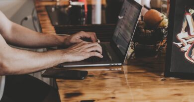 person in front of laptop on brown wooden table
