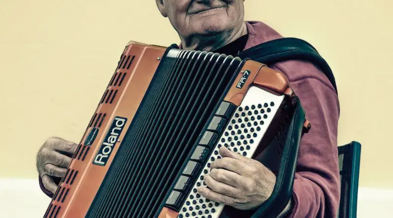 man sitting playing accordion