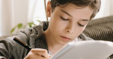 boy in gray hoodie holding white tablet computer