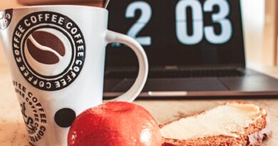 closeup photo of white and black printed ceramic mug beside pastry