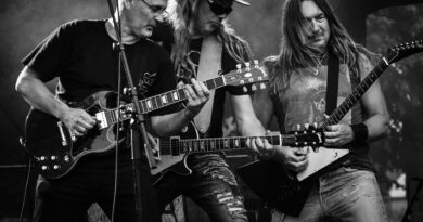 group of men playing guitar in concert in grayscale photo