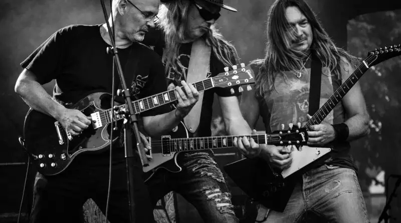 group of men playing guitar in concert in grayscale photo